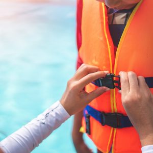 Mother helping her son to wear life jacket