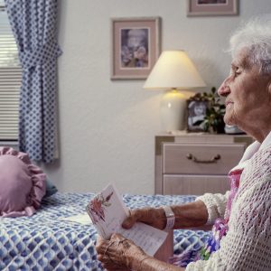 Old woman in nursing home room with letter